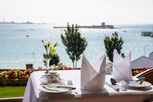 圣欧班潘拉玛旅馆的一张桌子,上面有白色的桌布,享有水景