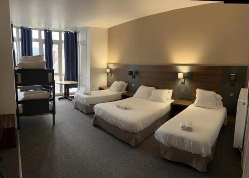 维希现代酒店的酒店客房设有两张床和一张桌子。