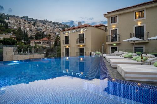 海法Hotel Botanica- Limited Edition By Fattal的大楼前设有游泳池的酒店