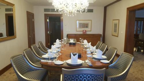 艾卜哈艾卜哈宫大酒店的一张带椅子和吊灯的长木桌子