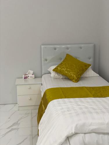 欧拉شاليه الجبل الاحمر 3的一张带黄色枕头和床头柜的床