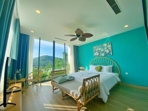 Thanh CaoVilla 3 bedrooms Venus resort by Flamigo with warm water swimming pool的蓝色的卧室设有床和大窗户