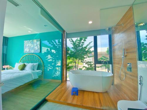 Thanh CaoVilla 3 bedrooms Venus resort by Flamigo with warm water swimming pool的带浴缸、床和窗户的浴室