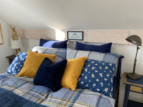 魏勒-锡默贝格Das blaue Haus - ein Sommertraum und ein Wintermärchen的一间卧室配有蓝色和黄色枕头的床