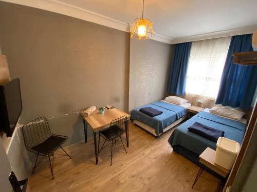 安塔利亚科斯克酒店的一间设有两张床和一张桌子及椅子的房间
