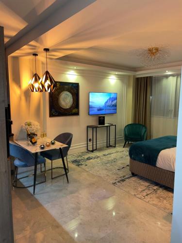 索恩河畔沙隆NUITS D'HERMES & Spa的一间卧室配有一张床、一张桌子和一台电视。
