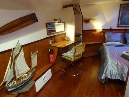 阿姆斯特丹Anna Houseboat的卧室配有一张床,墙上有小船
