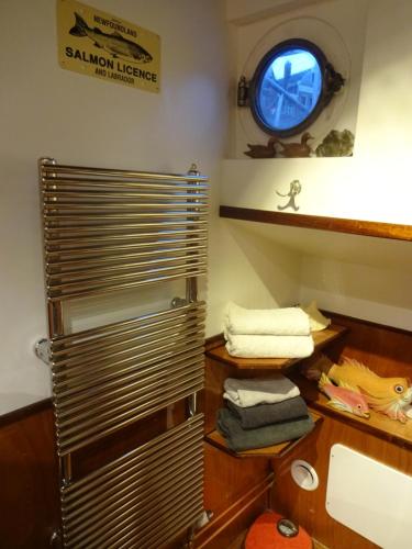 阿姆斯特丹Anna Houseboat的浴室设有水槽和带毛巾的架子。