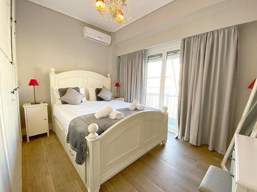 雅典Luxury Vacation by LV的卧室设有白色的床和大窗户
