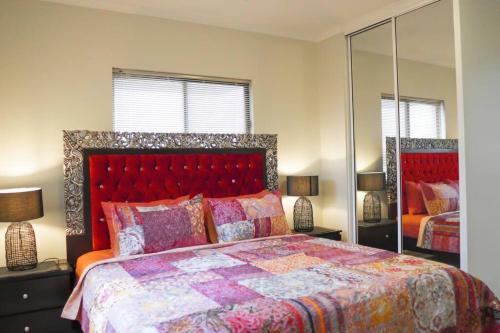 达尔文Top End Marvel -Darwin's Premier 3-BR Luxury Apt的一间卧室配有一张大床和镜子