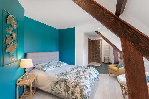 SavigniesAu Domaine Cru的卧室拥有蓝色的墙壁,配有一张床和椅子