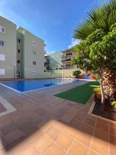 坎德拉里亚Los Menceyes Yaral的一座棕榈树和建筑的游泳池