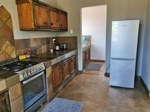 白河Rustic Country Cottage的厨房配有木制橱柜和白色冰箱。
