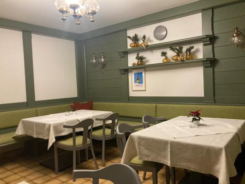 玛丽亚阿尔姆Rosi`s的餐厅配有2张桌子和椅子以及白色的桌布