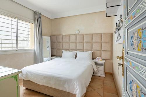塞拉La villa des corsaires, vue panoramique sur Rabat的卧室配有白色的床和窗户。