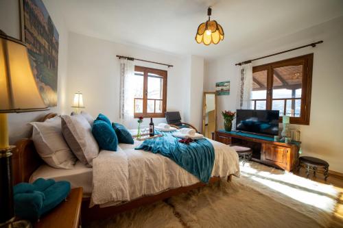 Villa Pallas的一间卧室配有一张带蓝色枕头的床和电视。