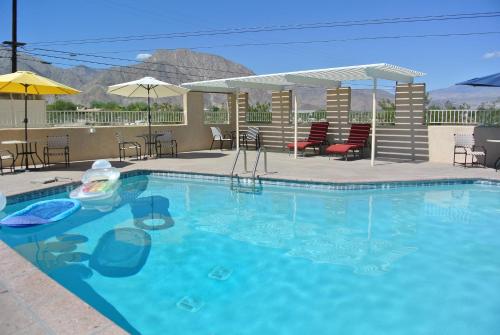 博雷戈斯普林斯Borrego Springs Motel的度假村内带椅子和遮阳伞的游泳池