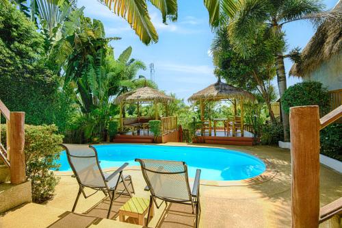 高兰Villa Siam Lanna at Kantiang Bay的一组椅子和一个游泳池