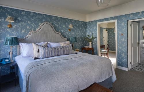 利明顿Stanwell House的一间卧室配有一张带蓝色壁纸的大床