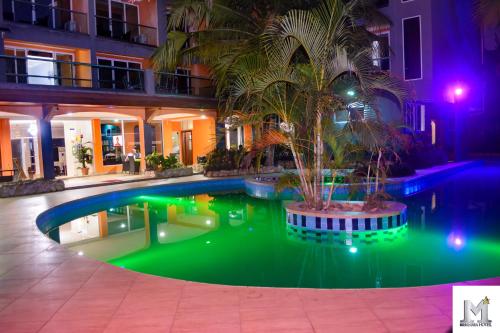 阿克拉Mendiata Hotel的一座建筑前的游泳池,里面种着棕榈树