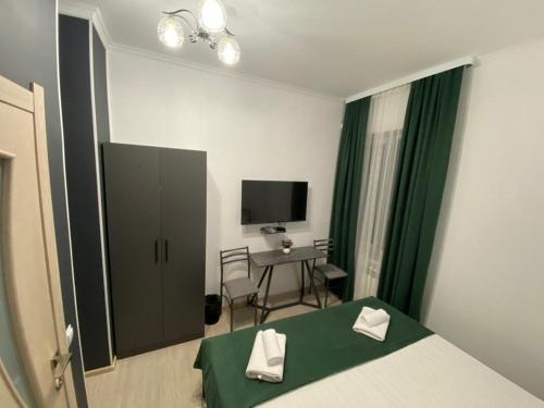 比什凯克A Hotel Bishkek的一间卧室配有一张床、一张书桌和一台电视