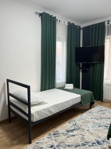 比什凯克A Hotel Bishkek的一间卧室配有一张带绿色窗帘的床和钢琴