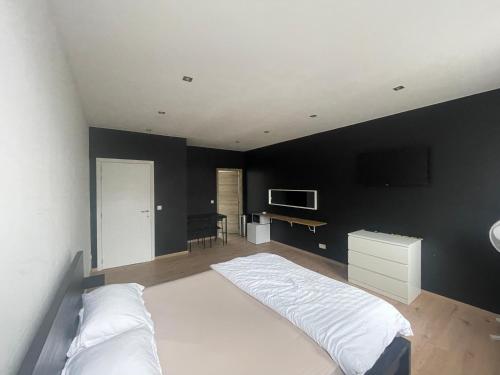 图尔奈Room of Tournai 3的卧室配有白色的床和黑色墙壁