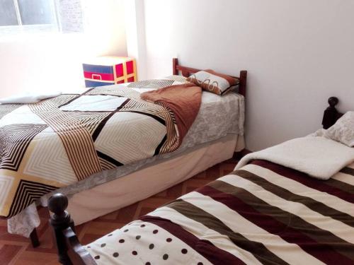 齐克拉约Departamento-Parque y Flores M1的卧室内两张并排的床
