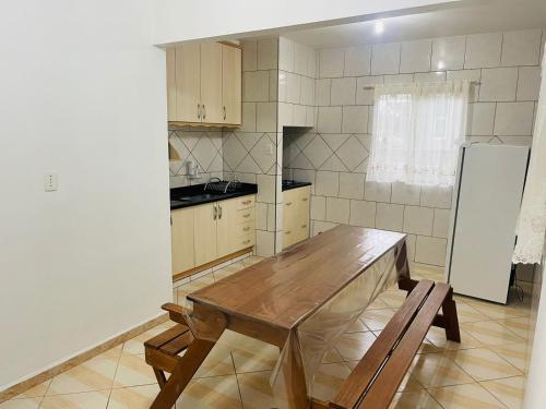 波梅罗迪Suites da Rota - Pomerode SC的厨房配有木桌和冰箱。