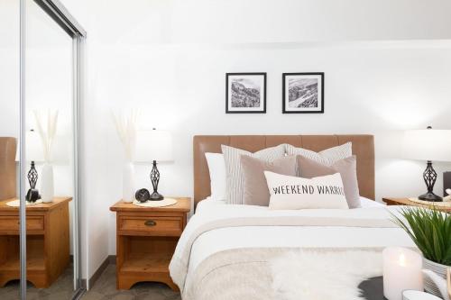 惠斯勒Slopeside Whistler Creek的一间卧室配有一张床和两张带台灯的桌子。