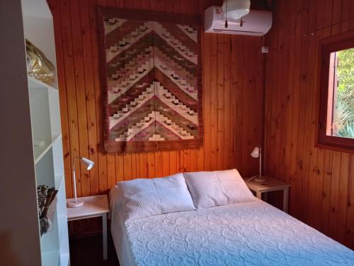 拉帕洛马Maneki的卧室配有一张床,墙上挂着被子