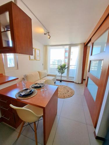 康塞普西翁Céntrico y cómodo departamento的厨房以及带桌椅的起居室。