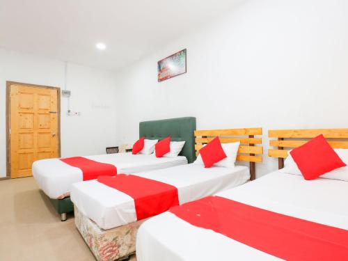 哥打巴鲁Citra Kadok Hotel & Banquet Hall的一间设有4张红色和白色床单的房间