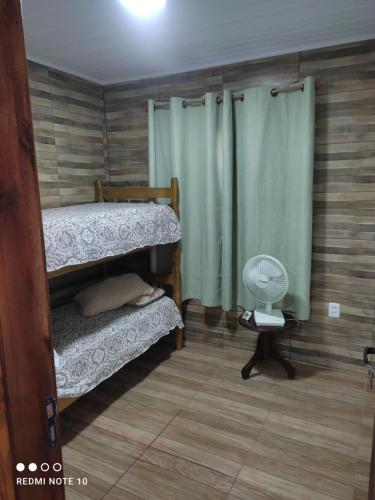 巴拉德尔楚Cafofo SE RESERVA CON SEÑA的客房设有两张双层床和风扇。