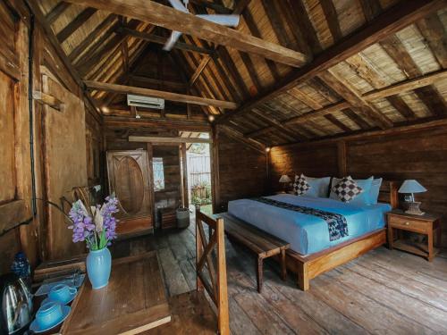 博拉巴图Sarini Villas的一间卧室设有一张床和木制天花板