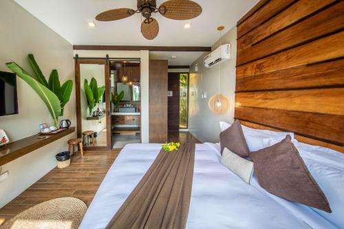 爱妮岛Ahana Resort El Nido的一间卧室配有一张大床和木制床头板