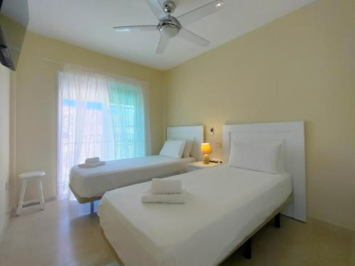 波多黎各Apartment With Jacuzzi and pool access的一间卧室设有两张床和窗户。