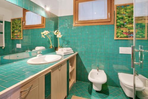 博尔米奥Casa Rossella的蓝色瓷砖浴室设有卫生间和水槽