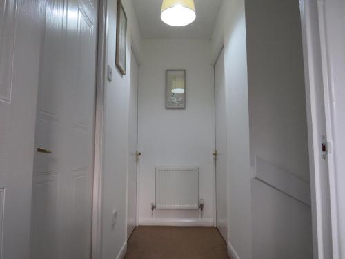 诺丁汉Remarkable and perfect 3 Bed House in Nottingham的一条带白色墙壁和门的走廊