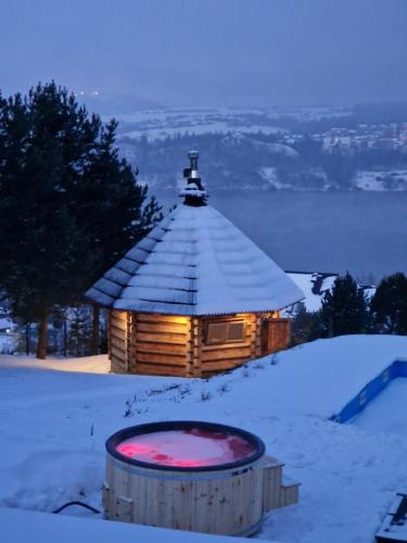 涅兹卡城堡Mergen Bike & Ski Resort的雪地小木屋,前面设有浴缸