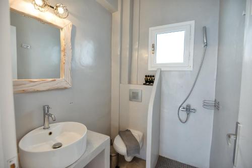 佩里萨Aspro Phos Santorini Hotel的白色的浴室设有水槽和淋浴。