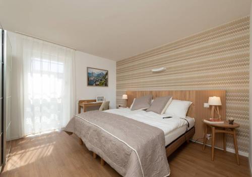 CollombeyAlp Art Hotel的一间卧室设有一张大床和一个窗户。