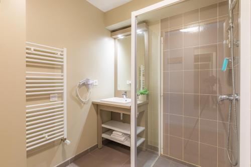 瑟松塞维涅雷恩-瑟松塞维涅城市公寓酒店的带淋浴和盥洗盆的浴室