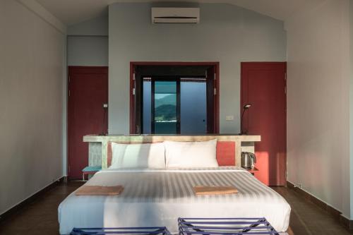 万荣萨图楠姆比奇度假村的一间卧室设有一张带红色墙壁的大床