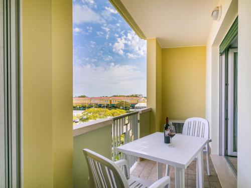 杜纳维德Apartment Robinia-Pinetine-1 by Interhome的阳台配有白色的桌椅和窗户。