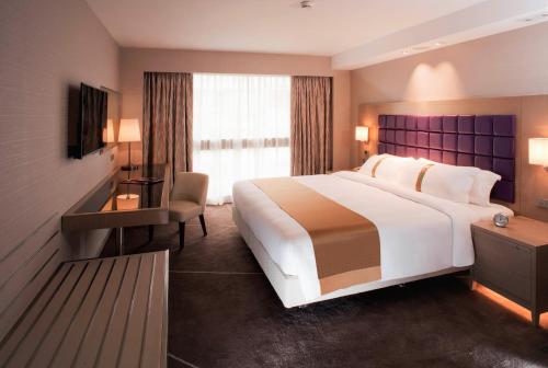 香港香港金域假日酒店的酒店客房设有一张大床和一张书桌。