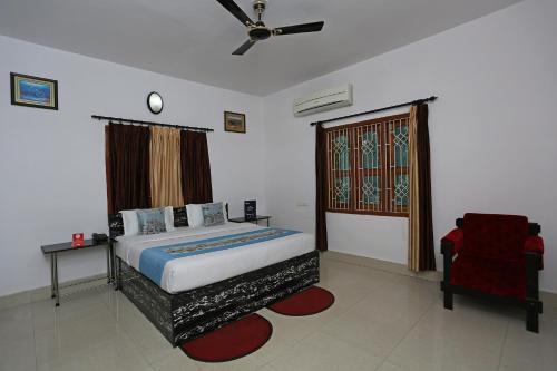 布巴内什瓦尔OYO Maa Banadurga Inn的一间卧室配有一张带吊扇和椅子的床