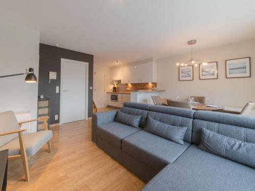 布列登Apartment Residentie Havenhuys-2 by Interhome的一间带蓝色沙发的客厅和一间厨房