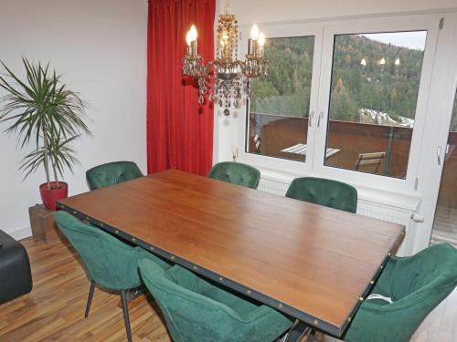 塞费尔德附近赖特Apartment Isolde by Interhome的一间带木桌和绿色椅子的用餐室