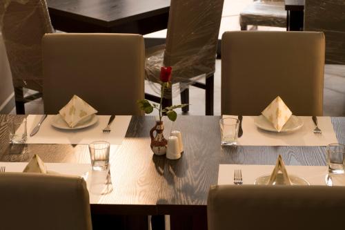 RouibaHotel Bournissa的餐厅里一张带盘子和餐具的桌子